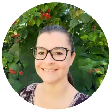 Ana Hill, MA, smiling therapist with glasses in front of green foliage, representing Sunshine State Counseling Center's team of mental health professionals.