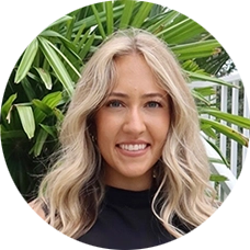 Madalyn “Maty” Tuttle, MSW, therapist at Sunshine State Counseling Center, smiling in front of lush greenery.