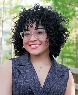 Karinna Chaluisant, consejera en Sunshine State Counseling Center, sonriendo en un entorno natural.