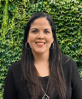 Kathleen Rodriguez, terapeuta en Sunshine State Counseling Center, sonriendo frente a un fondo de hojas verdes, representando servicios de consejería en español en Bonita Springs, FL.