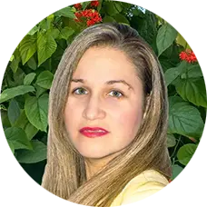 Lilian R. Burgos Martinez, MS, therapist at Sunshine State Counseling Center, posed against a backdrop of lush green foliage and vibrant flowers.